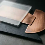 Acrylic vs wood vs metal signage materials compared, with a frosted acrylic panel, copper sheet and dark board laid side by side